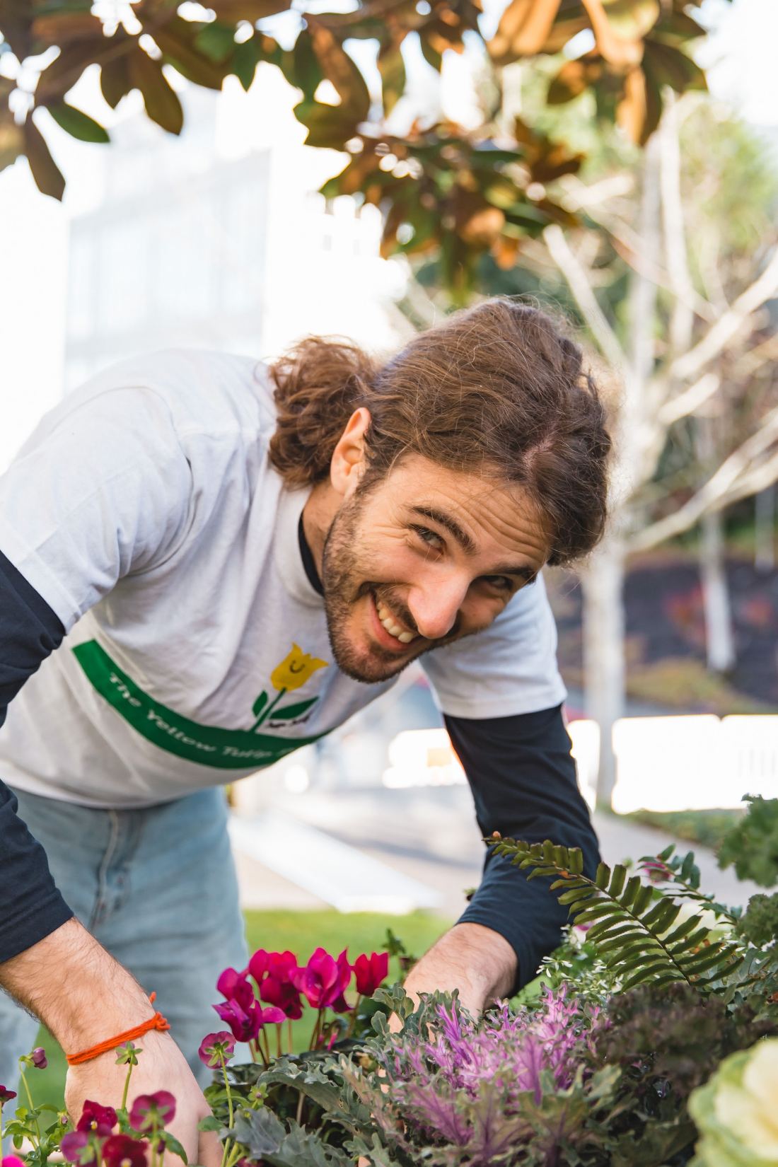 Mentor Dida planting flowers outdoors with a community volunteering group